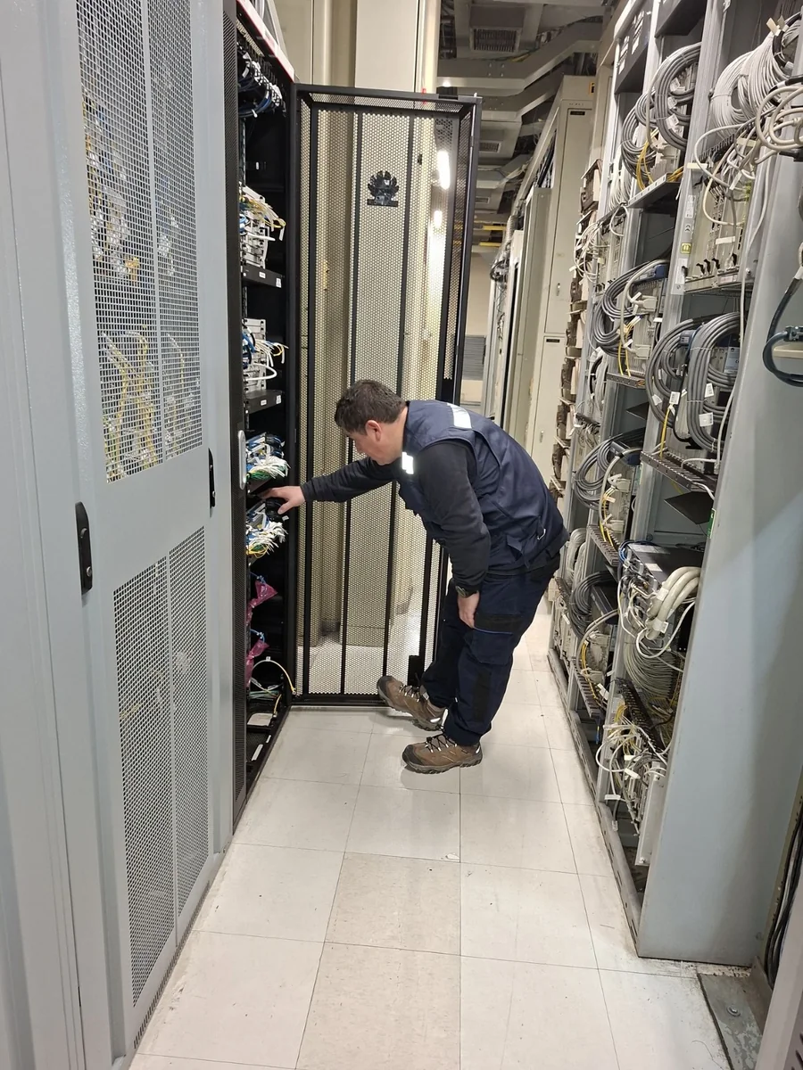 Técnico de Tamatel operando un gabinete de infraestructura crítica en sala técnica